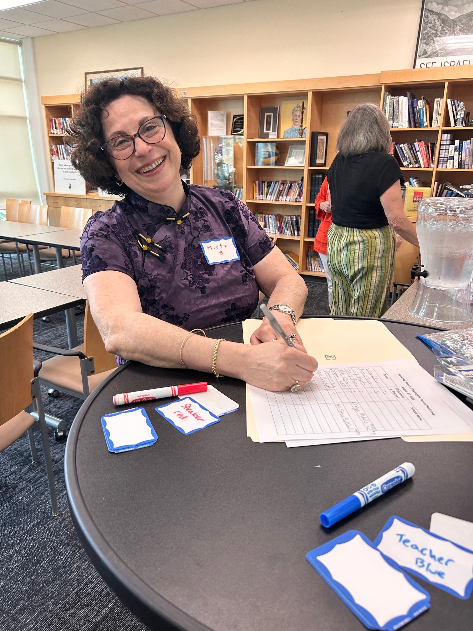 Mirta Glasman at Sign In Table — Speaker-Teacher Workshop at Levin JCC, August 2, 2026